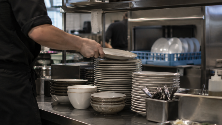 Vajilla resistente para hostelería apilada en cocina profesional